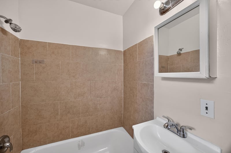 Bathroom with tan tile and pedestal sink at 2132 Allandale Cir W, Jacksonville, FL