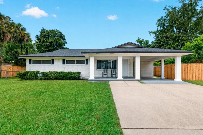 Front exterior with covered carport and lawn at 9506 Harriet Ave, Jacksonville, FL 32208