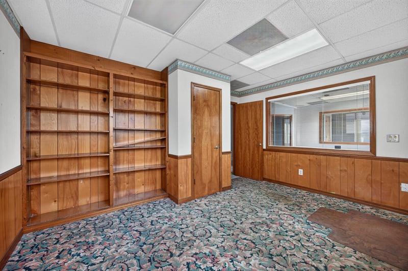 Room with built-in wood shelving and floral carpet at 1543 Kingsley Ave #19, Orange Park, FL 32073