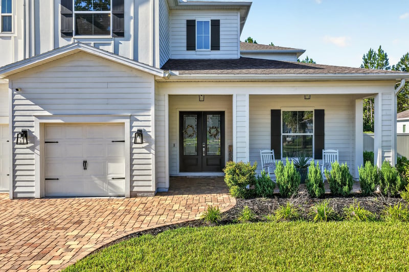Side exterior view of garage and brick driveway at 22 Azura Point