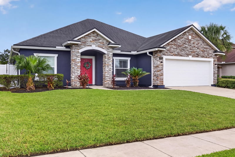 Front exterior with dark siding and red door at 538 Porta Rosa Circle, St. Augustine, FL 32092