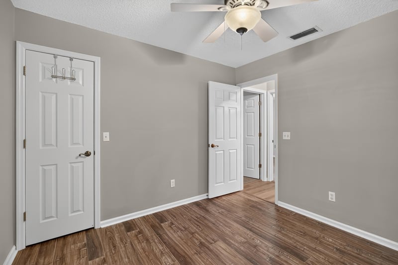 Bedroom with double doors and wood floor at 1955 GUARDED Way, Fleming Island, FL 32003