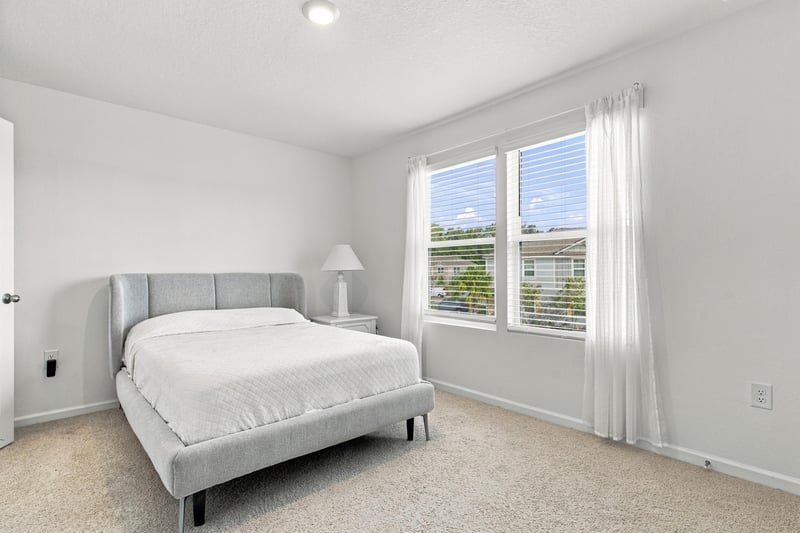 Bedroom with upholstered bed and window at 8359 Zenith Cir, Jacksonville, FL 32256
