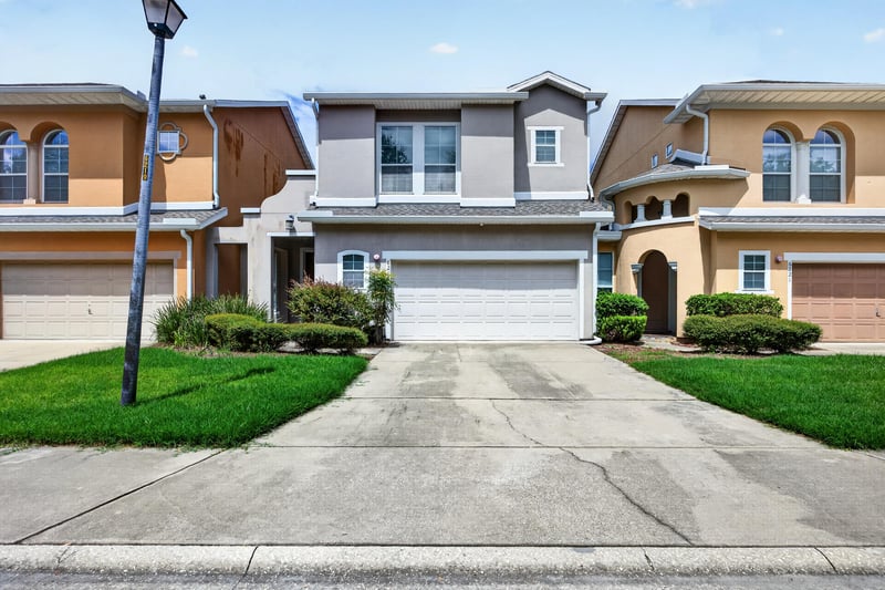 Front exterior with two-car garage and landscaped lawn at 6217 Eclipse Cir, Jacksonville, FL 32258