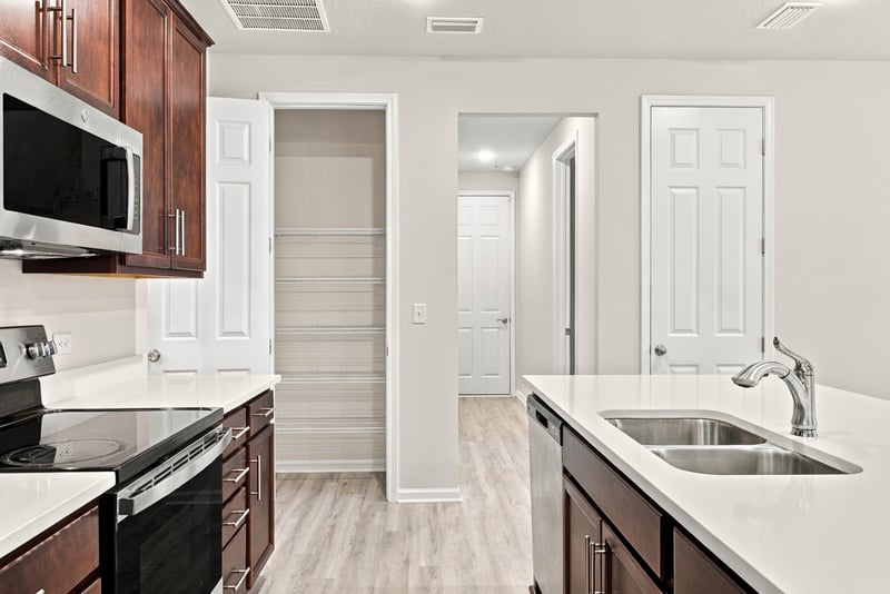 Kitchen with built-in microwave and pantry doors at 7088 Mahogany Run Dr, Jacksonville, FL 32244