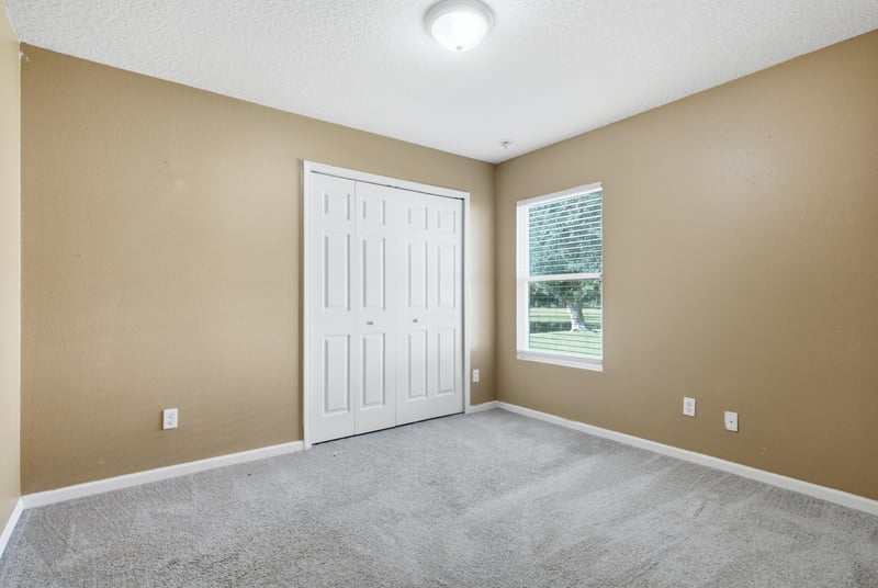 Empty bedroom with closet and window at 7392 Timber Falls Ct