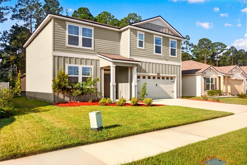 Front exterior with covered entry and manicured lawn at 65255 Frst Glen Ln, Yulee, FL 32097