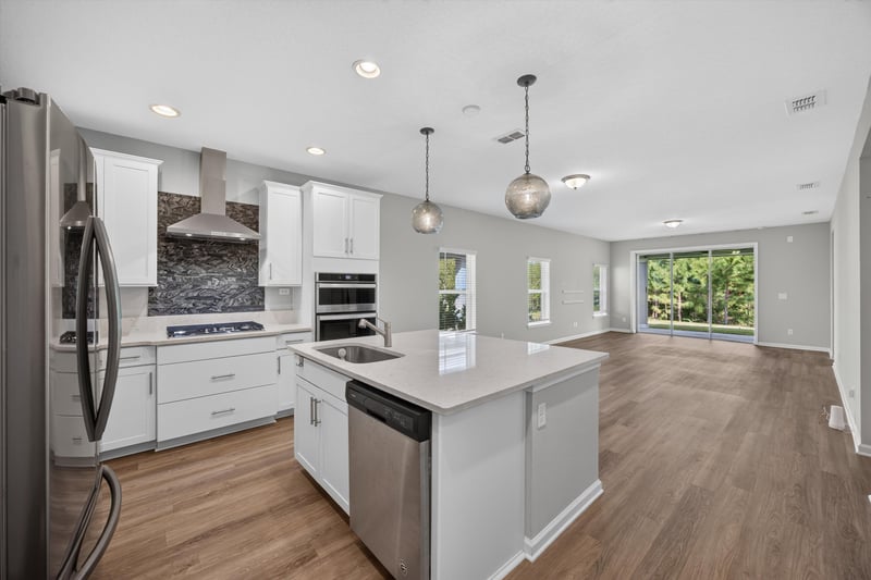Kitchen with stainless refrigerator and pendant lights at 75875 Saffron Ln, Yulee, FL 32097