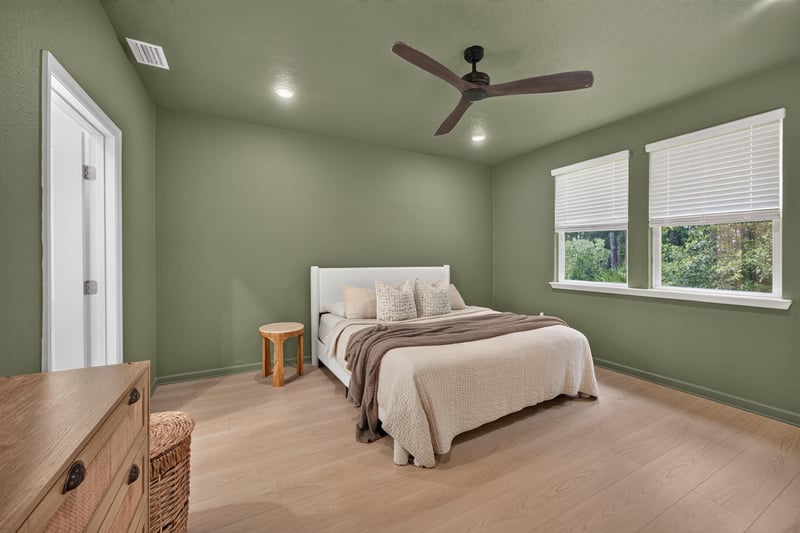 Primary bedroom with green accent wall and ceiling fan at 93 Lochloosa Ct, St. Johns, FL 32259