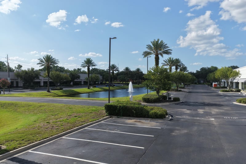 Palm-lined parking lot with pond in the distance at 10550 Deerwood Park Blvd, Jacksonville, FL 32256