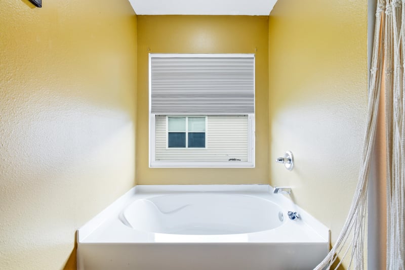 Primary bathroom with soaking tub and window at 7392 Timber Falls Ct