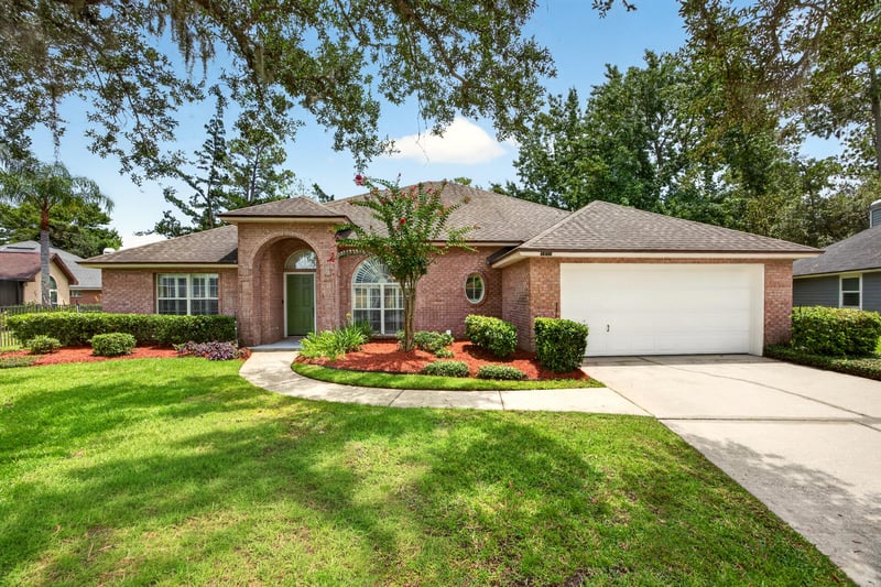 Front exterior with driveway and manicured lawn at 1955 GUARDED Way, Fleming Island, FL 32003
