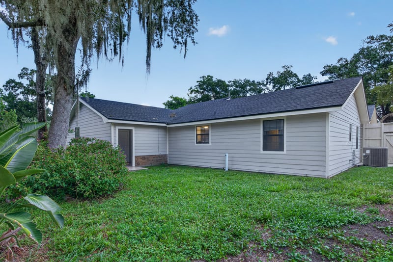 Backyard at day-to-dusk with siding exterior and mossy trees at 12344 Cormorant Ct, Jacksonville, FL