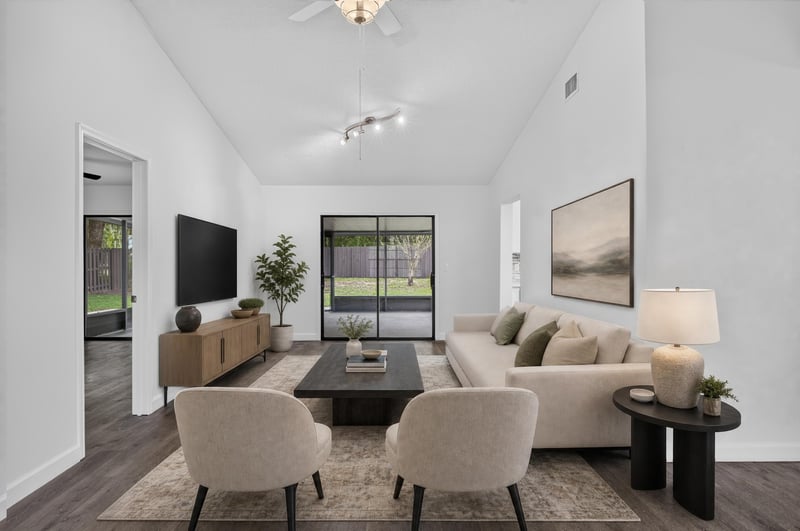 Living room staged with sofa, chairs and TV at 551 Deltona Blvd, St. Augustine, FL 32086