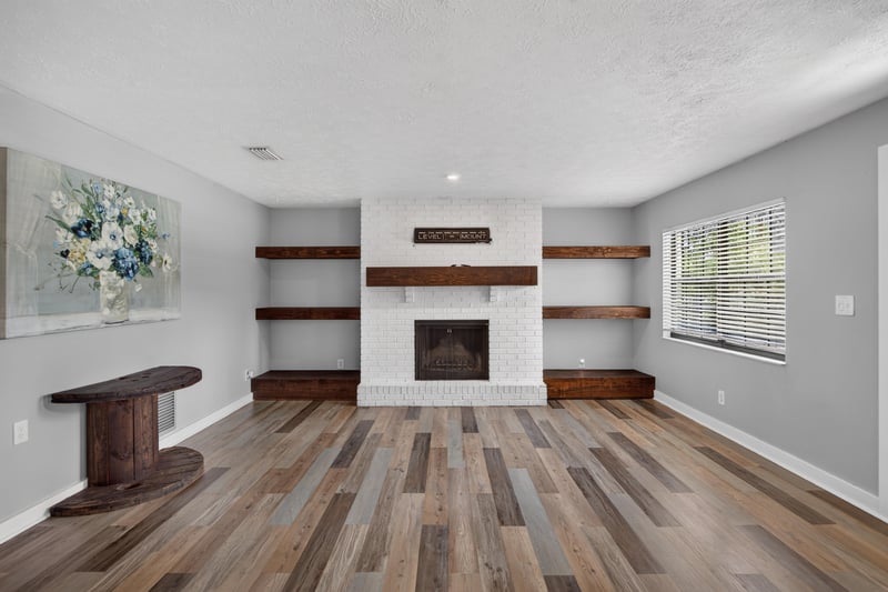 Living room with fireplace and wood-look flooring at 6757 Deer Springs Rd, Keystone Heights, FL 32656