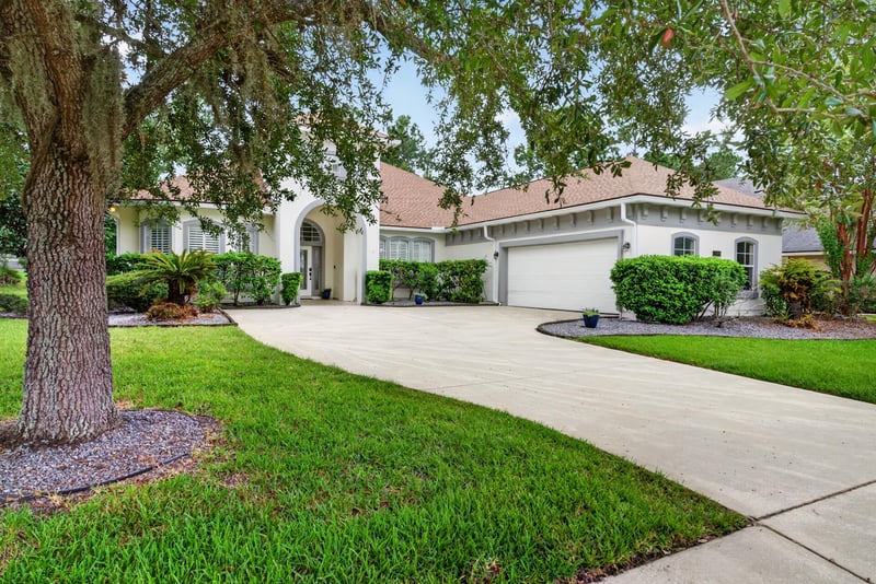 Front exterior under oak tree with three-car garage at 4109 Eagle Landing Pkwy, Orange Park, FL 32065