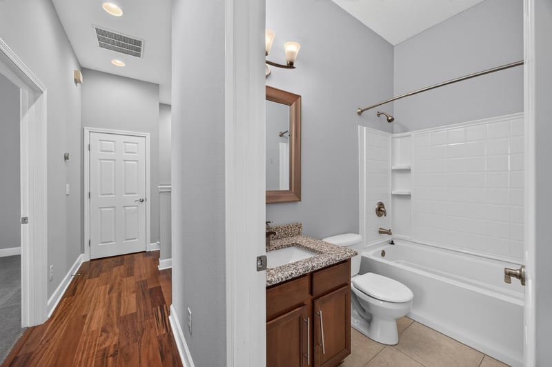 Hallway leading to bathroom with wood floors at 6217 Eclipse Cir, Jacksonville, FL 32258