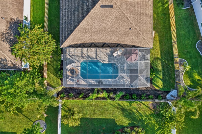 Aerial view of the screened pool enclosure and yard at 3328 Southern Oaks Dr, Green Cove Springs, FL 32043