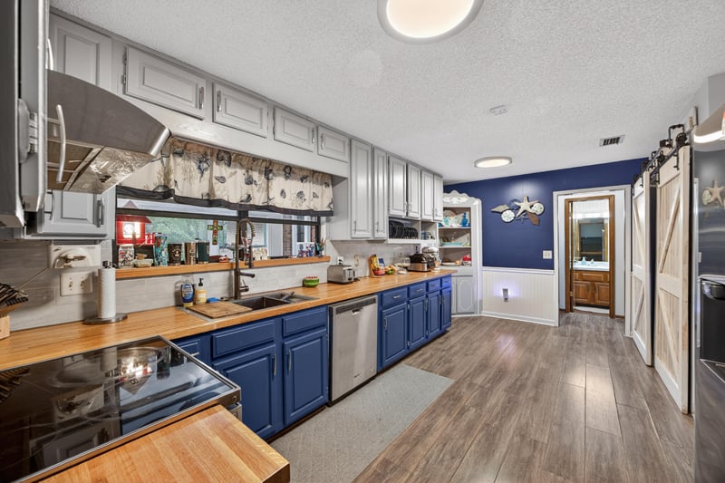 Kitchen with sliding barn door and tile backsplash at 981 Marble Ridge Dr, Orange Park, FL 32065