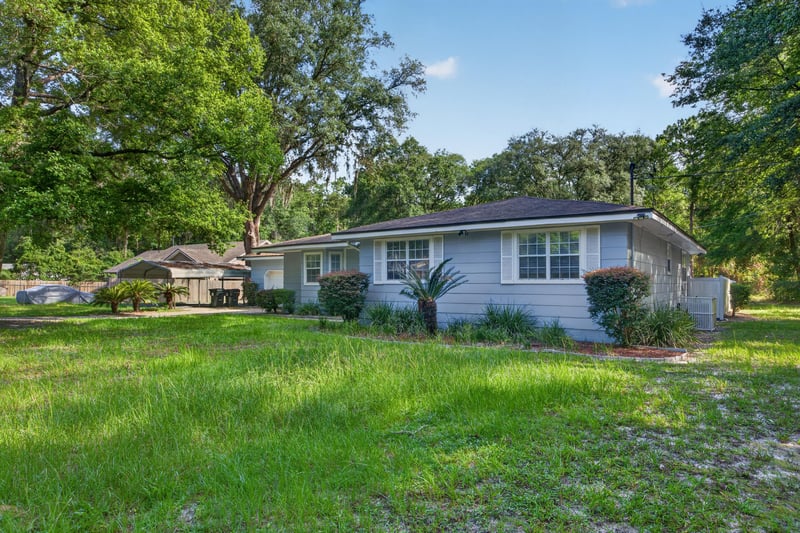 Front exterior showing garage and landscaped lawn at 892 Branscomb Rd, Green Cove Springs, FL