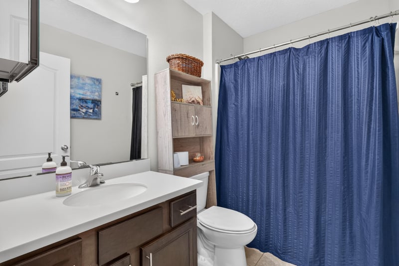 Bathroom with vanity and blue shower curtain at 589 Seville Pkwy, St. Augustine, FL