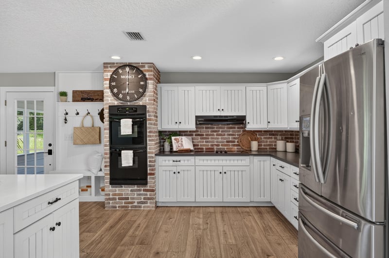 Kitchen with brick backsplash and wall clocks at 1161 Whispering Pines Rd, Jacksonville, FL 32259