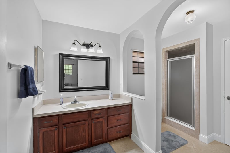 Bathroom with dark wood vanity and mirror at 2435 Range Line Rd, Middleburg, FL