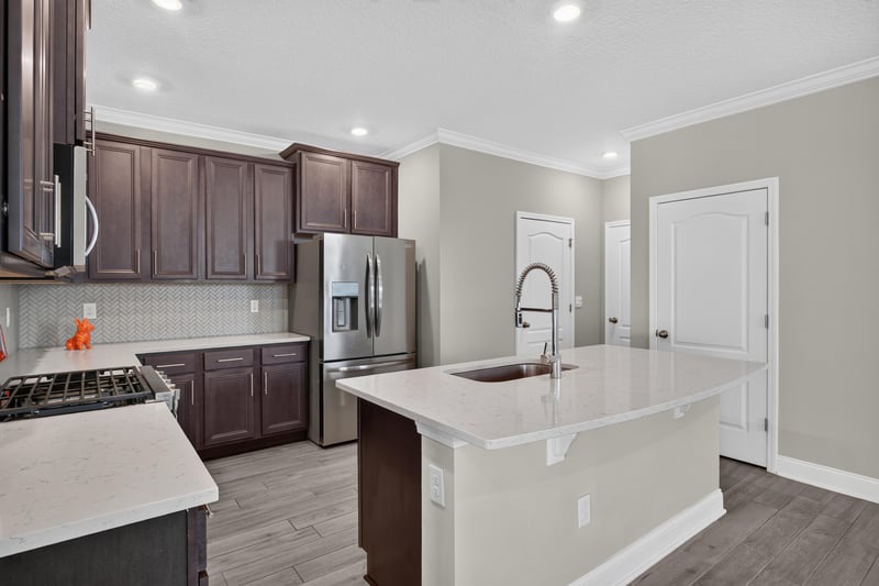 Kitchen with dark cabinets and quartz island at 331 Millerstone Dr, St. Augustine, FL 32092