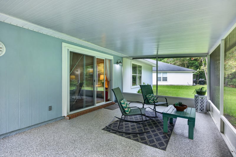 Screened porch with patio furniture and sliding glass door at 13514 Las Brisas Way N, Jacksonville, FL