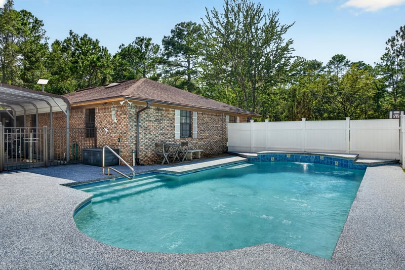 Pool with gravel deck under screened enclosure at 2435 Range Line Rd, Middleburg, FL