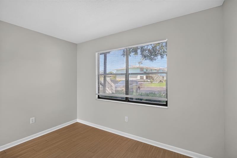 Bedroom with window and wood-look flooring at 700 W Pope Rd unit h61, St. Augustine, FL 32080