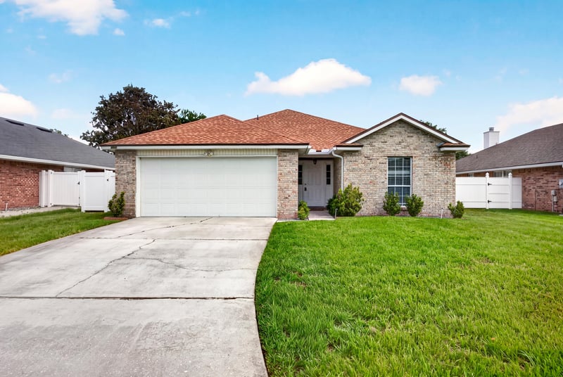 Front exterior with brick facade, tile roof, and two-car garage at 490 Hillside Dr, Orange Park, FL 32073