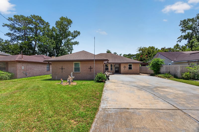 Front exterior view from driveway showing lawn and attached garage at 2460 San Sago Ln, Jacksonville, FL
