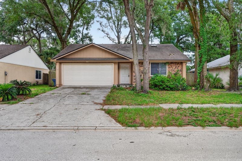 Front exterior under mature oak canopy at 1445 Classic Oak Rd W, Jacksonville, FL
