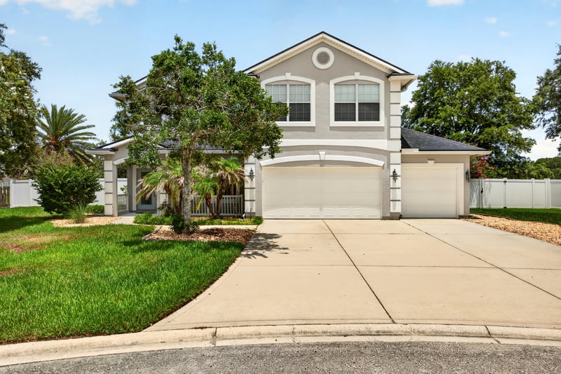 Front exterior with three-car garage and palm trees at 1493 Greyfield Dr, St. Augustine, FL 32092