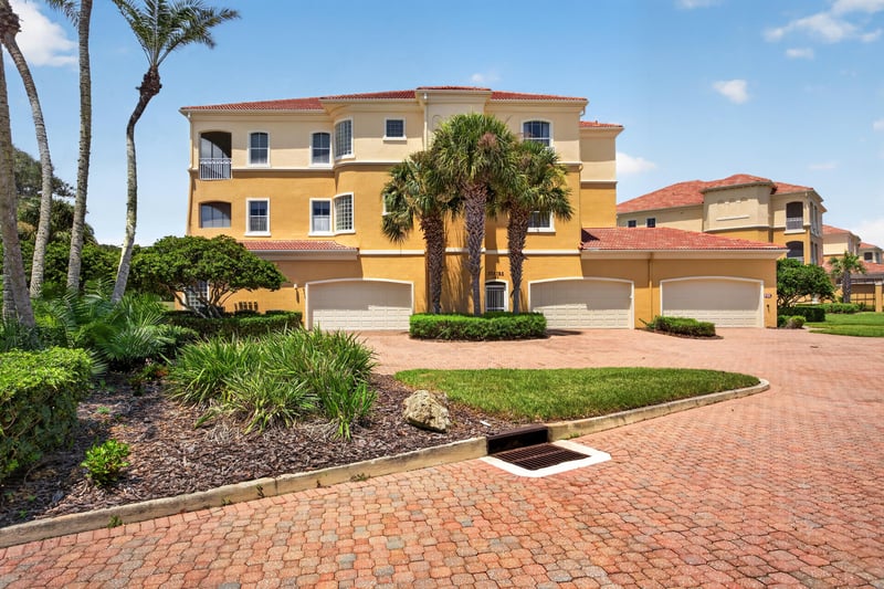 Aerial close-up of the home with palm trees and driveway at 140 Ave De La Mer, Palm Coast, FL 32137