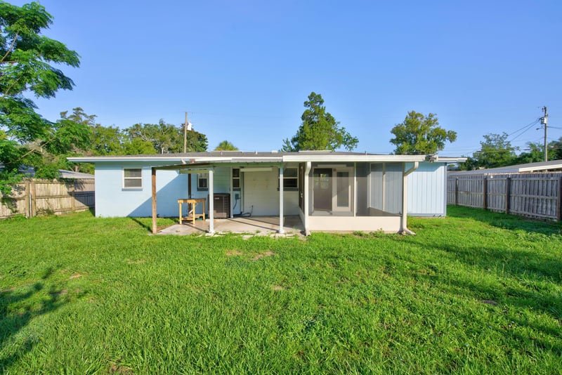 Back exterior with covered porch and lawn at 442 Ameca Ave, Orange Park, FL 32073