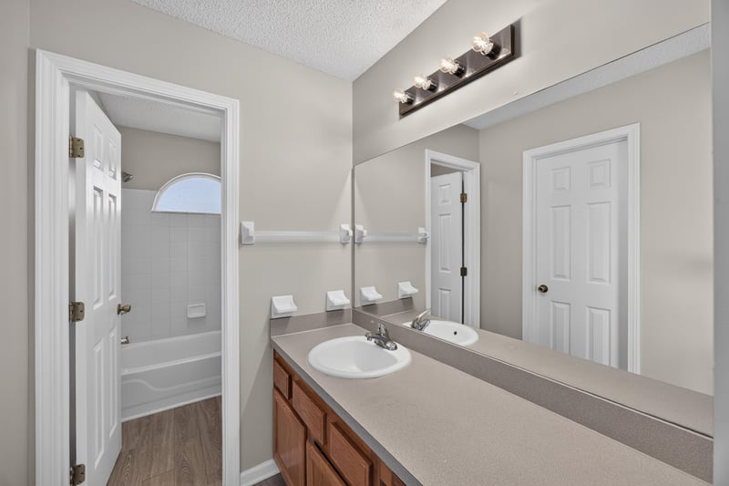 Bathroom vanity with mirror and light fixture at 8519 Blazing Star Ct, Jacksonville, FL 32210