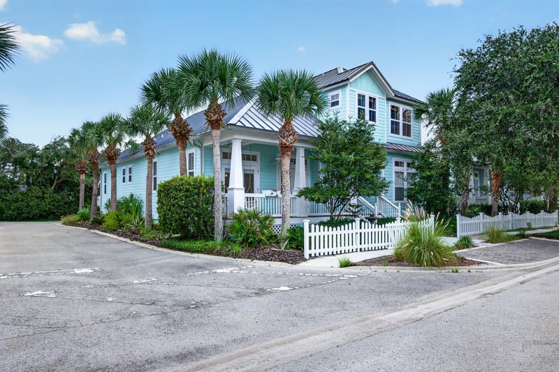 Front exterior with white picket fence and palm trees at 117 Island Cottage Way, St. Augustine, FL 32080