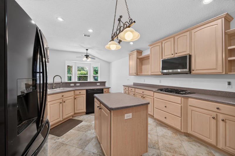 Kitchen with black appliances and center island at 11675 Magnolia Estates Rd, Jacksonville, FL 32223