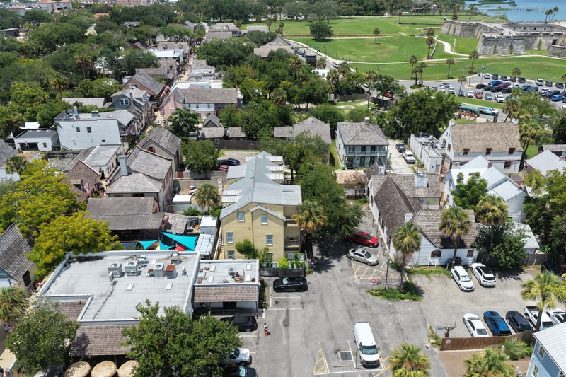 Aerial view over the green and surrounding rooftops toward the water in St. Augustine, FL