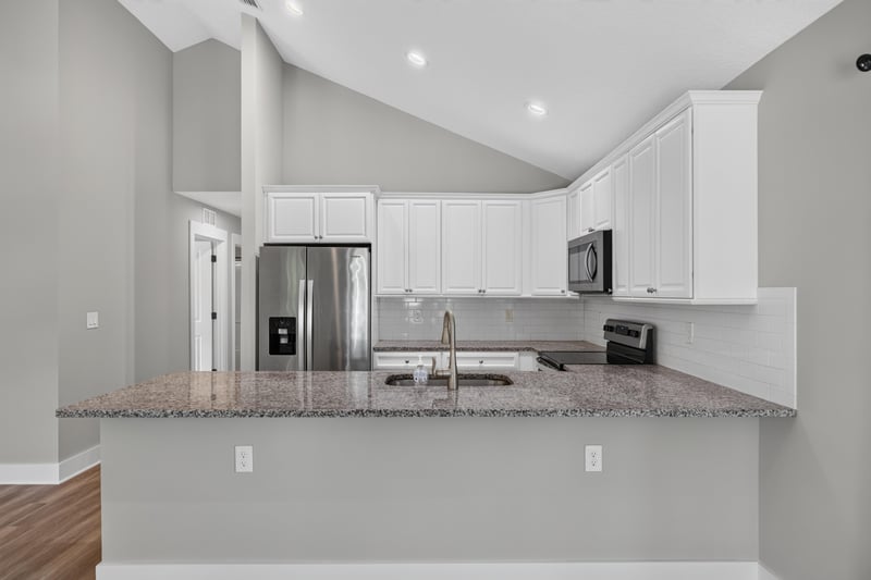 Kitchen peninsula with granite counter and stainless fridge at 2855 N 8th St, St. Augustine, FL 32084