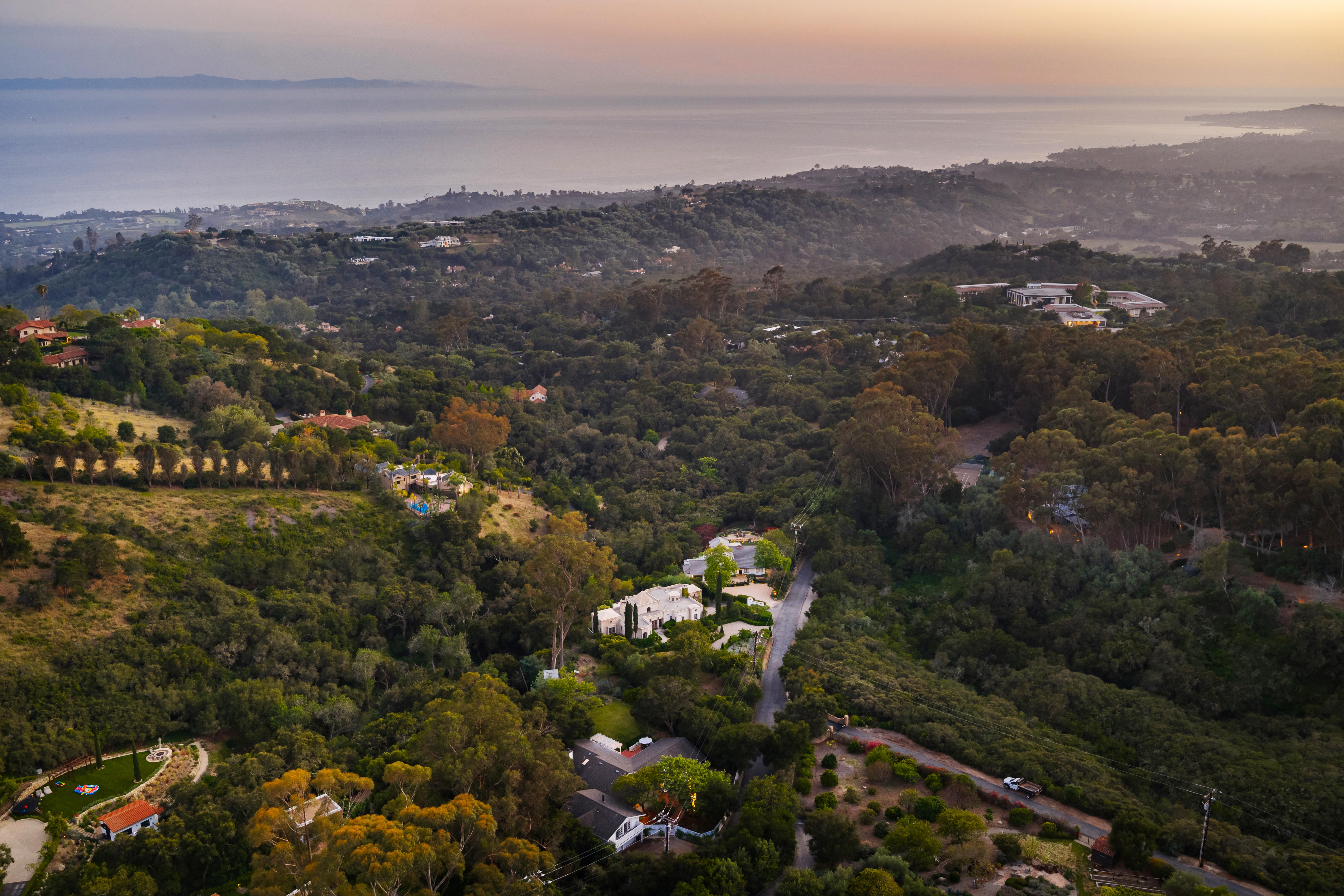 Drone aerial view of Hidden Valley Lane estate, Santa Barbara CA — the Pacific Ocean and Channel Islands emerge on the horizon beyond the roofline in this real estate drone photography image by VirTour Media, serving Montecito, Hope Ranch, and greater Southern California. Our team captured still photography, aerial drone photography, and twilight photography from late afternoon through twilight.