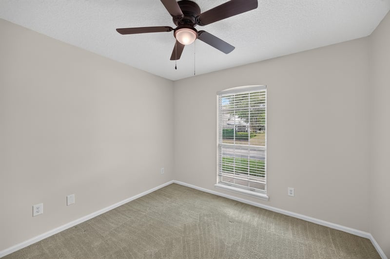 Secondary bedroom with carpet and window at 605 N Covered Bridge Rd, Jacksonville, FL