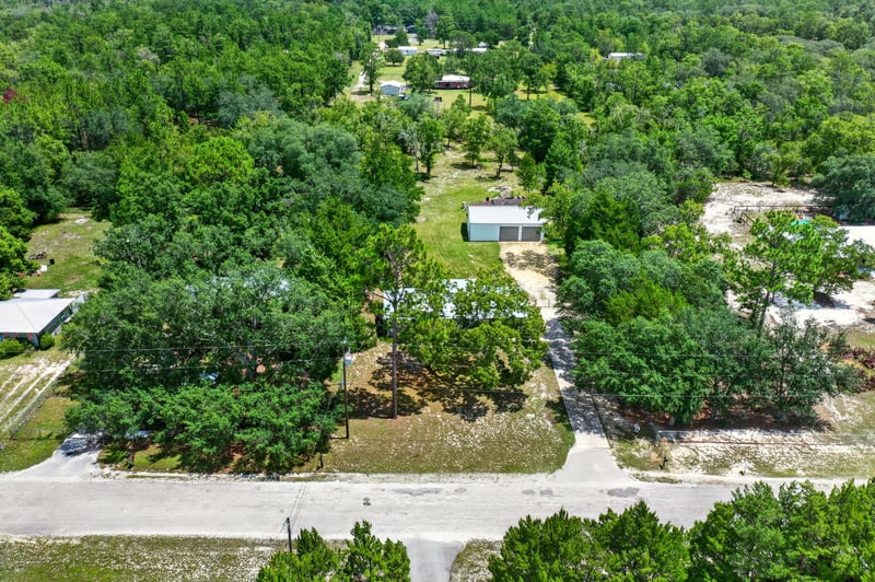 Aerial view of wooded lot with small outbuilding in Keystone Heights, FL