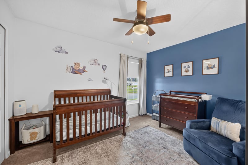 Bedroom with crib and blue accent wall at 12825 Kelsey Island Dr, Jacksonville, FL 32224