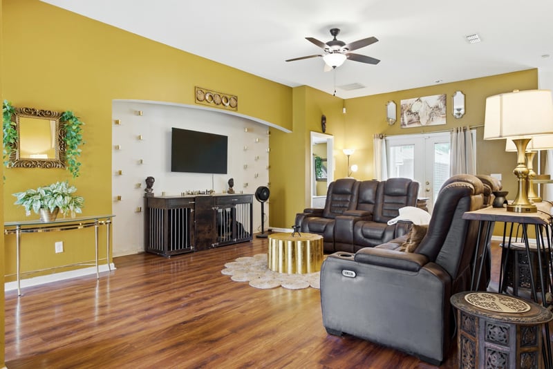 Living room with ceiling fan and built-in wall niche at 7392 Timber Falls Ct