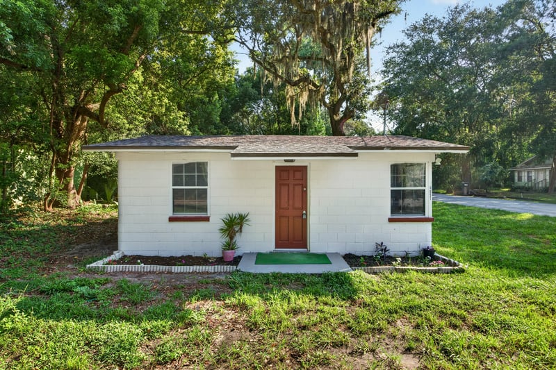 Front exterior with red door and oak trees at 4951 Halls Dr