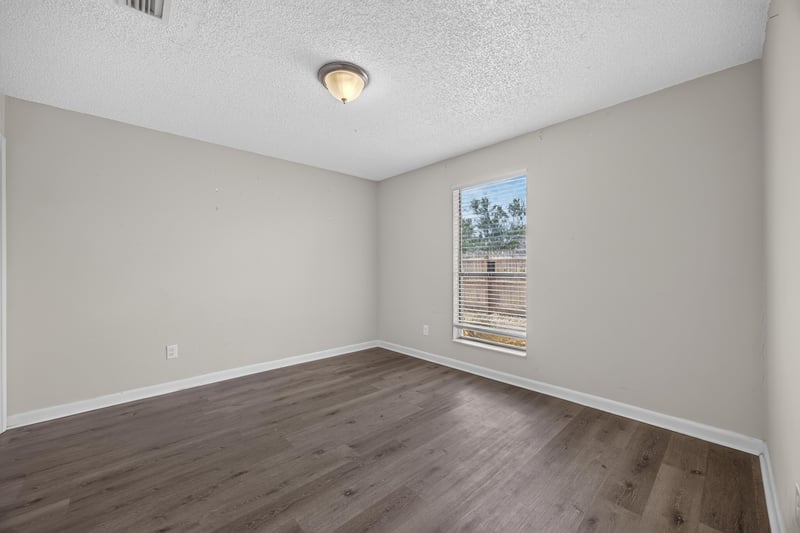 Bedroom with window and wood-look flooring at 2719 Trollie Ln