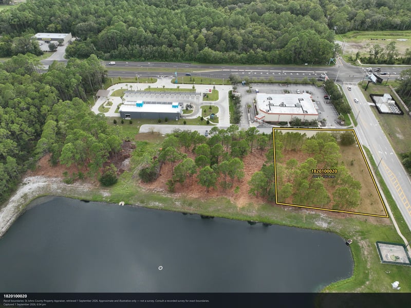 Aerial view of the pond and parking area near the wooded lot at 4900 US-1, St. Augustine, FL 32086